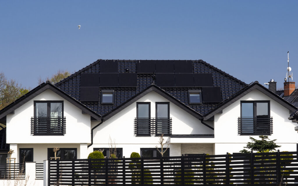 Roof of a private house in Europe with solar panels. Real estate with renewable energy source eco solar panels concept.